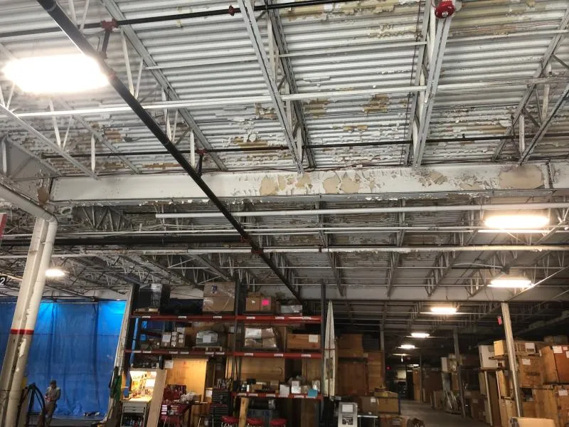 Warehouse ceiling deck vapor blasting - before