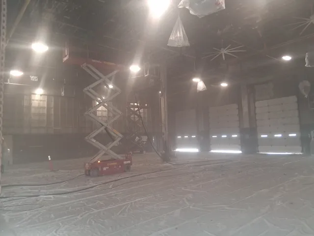 Blasting ceiling structure in semi-truck maintenance bay — dust in the air during blasting