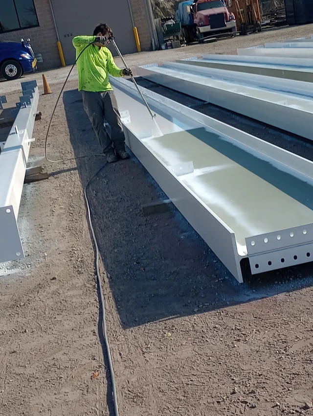 Spraying coating inside a structural steel channel — zinc primer, epoxy midcoat, urethane topcoat system